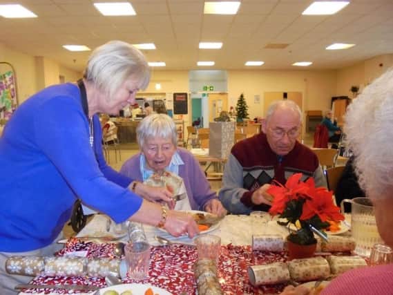 Jan Cox serving food on Christmas Day at the Royal Voluntary Service's lunch for older people last year. Photo: Royal Voluntary Service