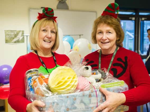 Sunshine Centre manager Jill Edge (left) receives a festive hamper of items collected by Sanctuary staff from neighbourhood partnerships manager Kate Winstanley. Photo: Sanctuary Group
