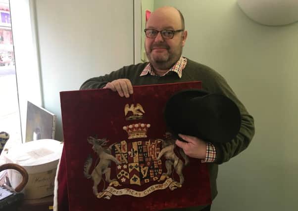 Holloway's auctioneer James Lees with Lord Lucan's top hat and coat of arms NNL-181101-135746001