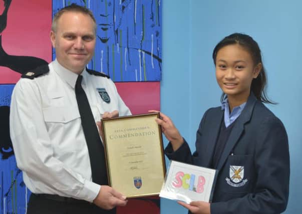 Superintendent Mark Johns presents Ysabella Mistula with her award for winning the logo competition. Photo: Thames Valley Police NNL-181001-164843001