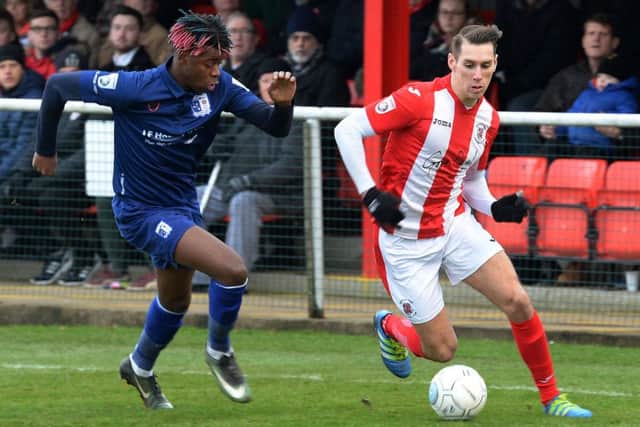 Brackley Town's Matt Lowe takes on Barrow's Donovan Makoma