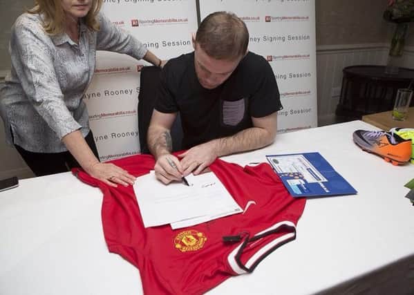 Trading standards officers revealed a Banbury couple's fake business by buying a shirt purportedly signed by footballer Wayne Rooney, pictured at a real signing with old club Manchester United FC, which was proven to be forged. Photo: Dorset County Council NNL-180115-152209001