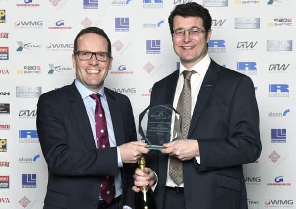 Prodrive's Tim Colchester, left, receives the award from Adrian Moore of Xtrac