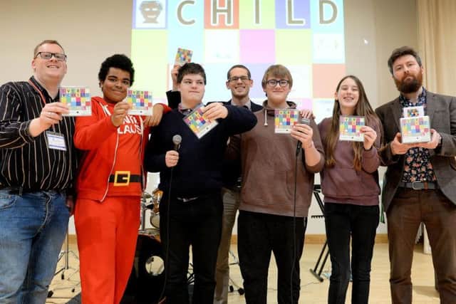 Andrew Smith from Barnardo's (left), NOA head of music Ben Judson (centre) and music teacher James Stevenson (right) with children from the school and the Sycamore Centre holding the Every Child CD