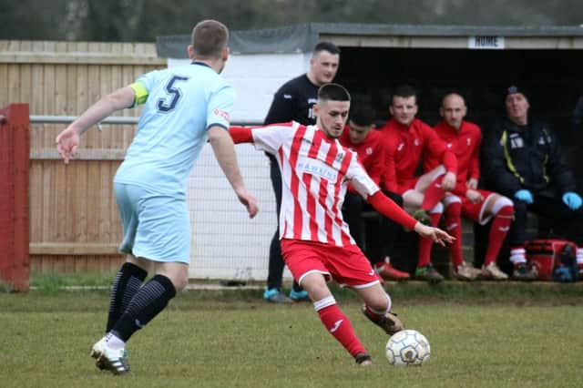 Easington Sports' Reece Bayliss gets in a cross despite the atentions of and Cirencester Town's Sam Farr
