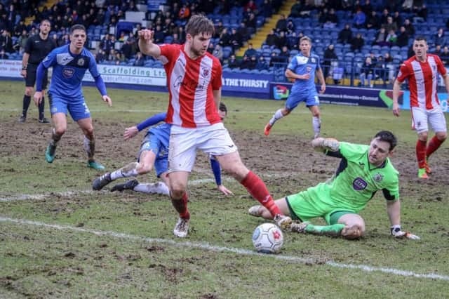 Brackley Town's Jimmy Armson evades Stockport County keeper Ben Hinchcliffe. Photo: Will Grantham