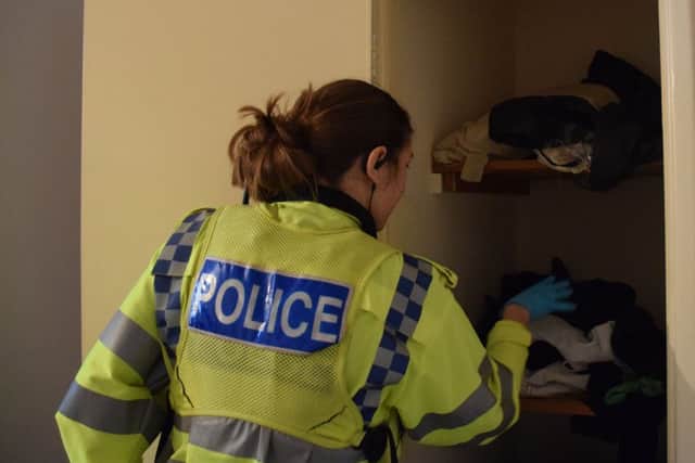 An officer goes through the belongings of a Banbury residence in search for evidence NNL-180418-124942001