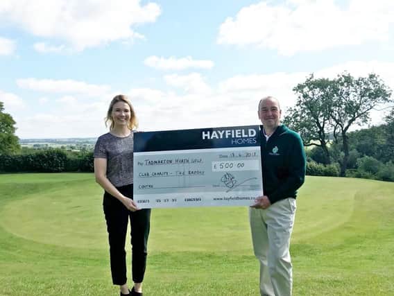 Hayfield Homes sales manager Harriet Dickson presents a 500 cheque to Tadmarton Heath Golf Club general manager Matt Draper. Photo: Hayfield Homes
