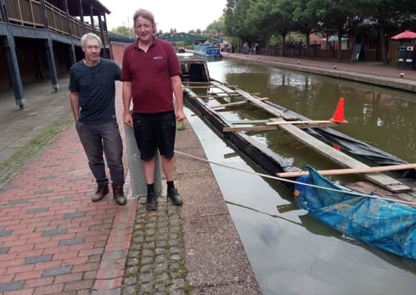 Jamie Simmons and Matt Armitage of Tooleys stand next to narrowboat Hardy which was sunk after a hit and run NNL-180813-153847001