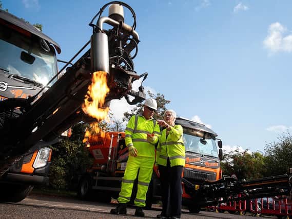 Dragon Patcher operator Tim Harris explains the new machine to Oxfordshire County Council cabinet member for environment Yvonne Constance. Photo: Ric Mellis