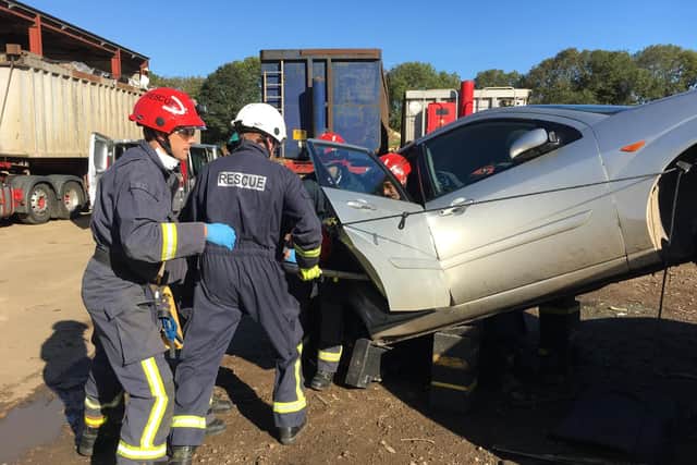 The team of Oxfordshire firefighters work together to get the passenger in the back seat of the car out safely