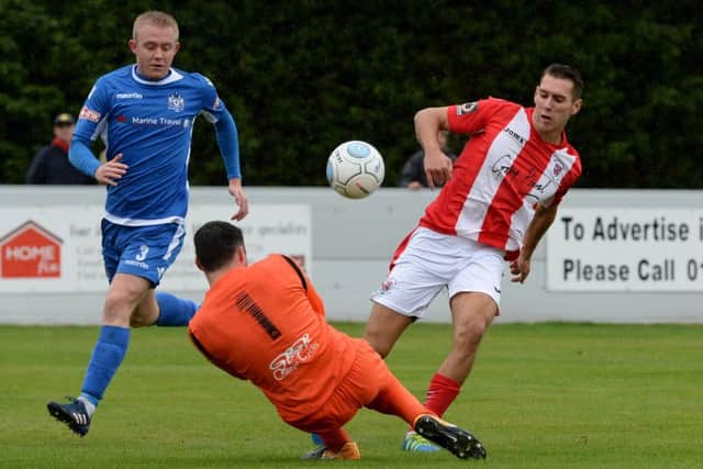 Brackley Town's Matt Lowe is foiled by  Marine keeper Martin Fearon and James Short. Photo: James McNulty