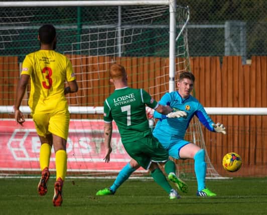 Biggleswade Town's Peter Clarke shoots wide as Banbury United keeper Jack Harding close him down while Marvin Martin looks on. Photo: Guy Wills
