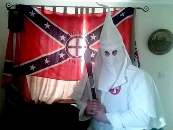 Adam Thomas alleged to be wearing a Ku Klux Klan robe while holding a knife in his Banbury living room. Photo: SWNS.com