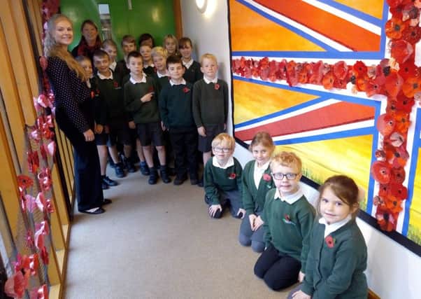 Teachers Mrs Messer (rear) and Ms Upstone with Year 4 students and the Armistice poppy memorial NNL-181113-094846001