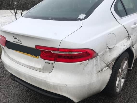 A Jaguar was damaged after crashing into the barrier on the M40 during the snow. Photo: Warwickshire Police
