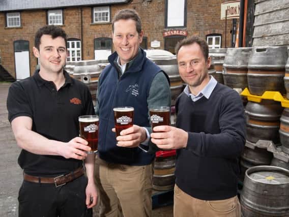 Cheers! Jamie OSullivan from Hook Norton Brewery, Charlie Longsdon and Andre Klein with a pint of The Kingmaker Ale. Photo: Warwick Racecourse