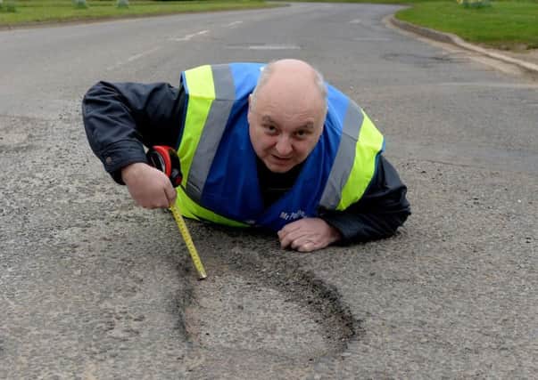 Mr Morrell gets a closer look at a pothole on Bankside