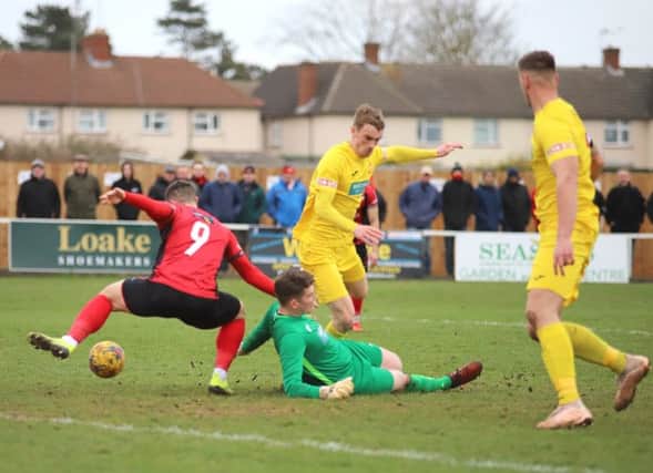 Kettering Town's Dan Holman tries to take advantage of Banbury United keeper Jack Harding being on the ground as Charlie Wise and Lee Henderson look on. Photo: Peter Short