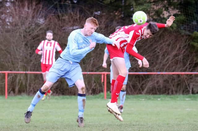 Easington Sports' striker Owen James gets in a header despite the attentions of Thornbury Town's Nathan Sage. Photo: Steve Prouse