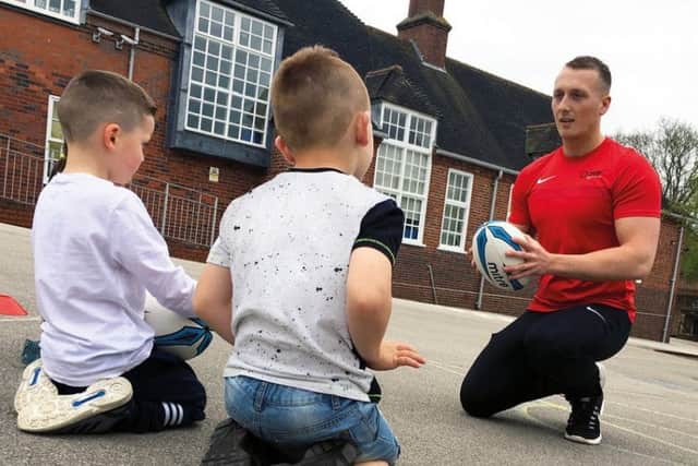 Tom teaches the kids some rugby tips