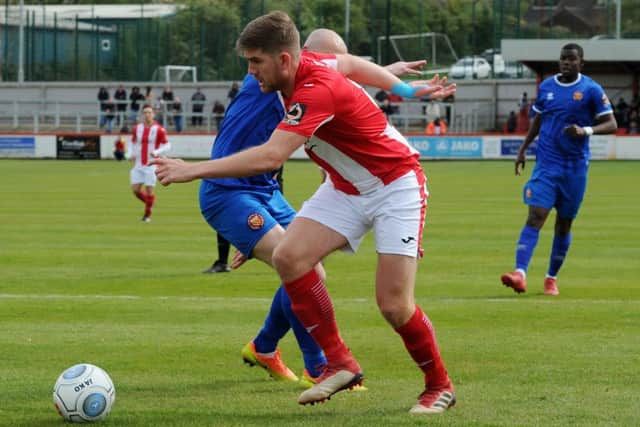 Brackley Town's Jimmy Armson turns FC United of Manchester's Chris Lynch. Photo: Jake McNulty