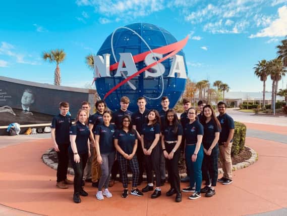 The students pose with the iconic NASA logo