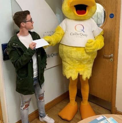 Castle Quay's Prettiest Pet 2019 competition winner Burt Kelly receiving the £100 voucher prize from mascot Sunny The Duck NNL-191206-162011001