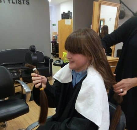 Ava Russell and her hair which will be made into a wig for a child with cancer NNL-190930-164840001