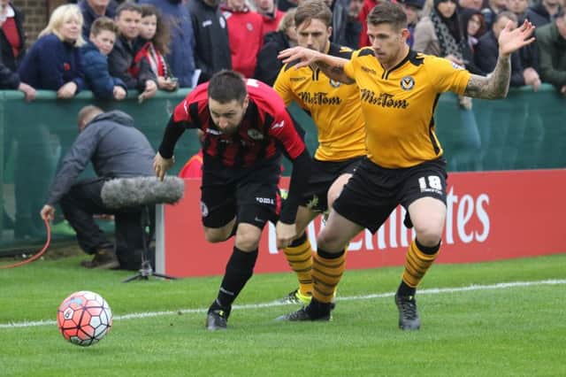 Brackley Town's Steve Diggin gets past Newport County's Scot Bennett in their Emirates FA Cup clash at St James Park. NNL-150811-174423001
