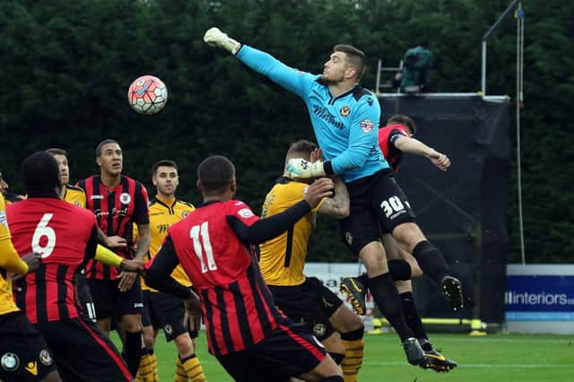 Newport County keeper Joe Day clears another Brackley Town attack at St James Park