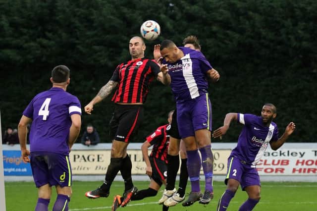 Brackley Town's Ryan Austin and Corby Town's Clayton McDonald challenge for the ball at St James Park