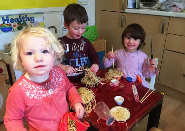 Winchcombe Farm Day Nursery celebrate Chinese New Year -  Isabelle Guppy James, Thomas Reddish and Libby King, all aged 4, get stuck into some noodles!