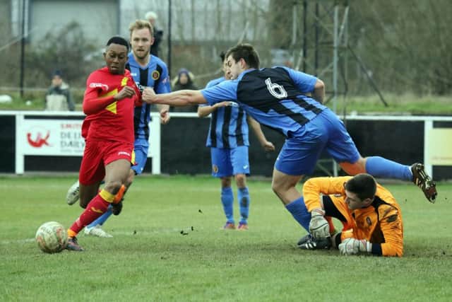 Banbury United's  Leam Howards is denied by Winchester City's Jamie Thoroughgood and keeper Brendan Norris at Spencer Stadium