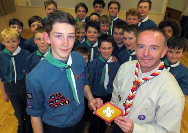 Ian Broome (right) presents Ben Haynes with his Chief Scouts Gold Award watched by other troop members. NNL-160318-092109001
