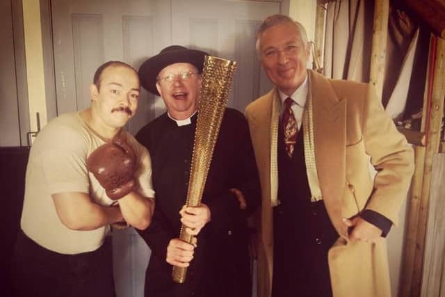 A boxer stands with Father Brown and boxing promotor played by Martin Kemp