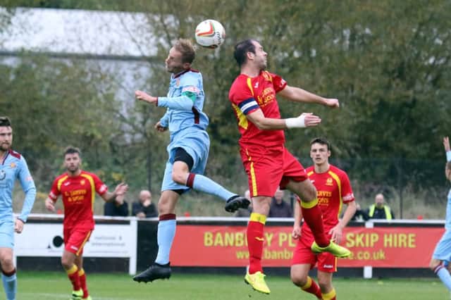 Banbury United skipper Andy Gunn and Bishops Cleeve's Kirk Layton go for a header during Saturday's FA Trophy tie