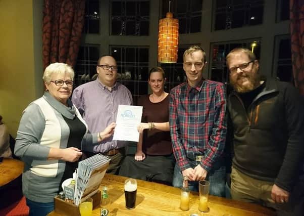 Bartender Kelly receives a certificate of appreciation from Radio Horton