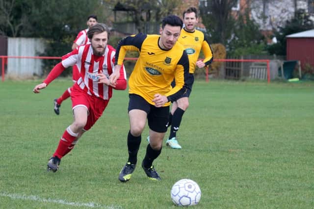 Easington Sports' Connor Grant pursues Heyford Athletic's Callum Lloyd