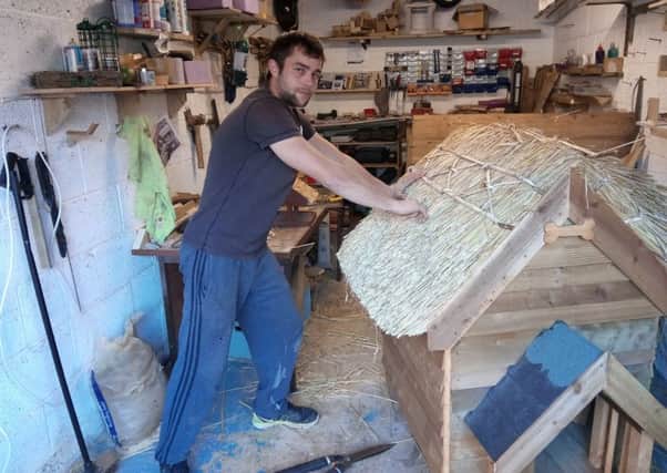 Daniel Peck at his Banbury workshop as he puts the finishing touches to a thatched dog kennel NNL-160112-125834001