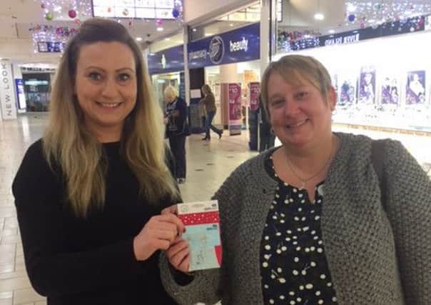 Rebecca Deeley, office manager at Castle Quay, presents Julia Thompson with the winners voucher NNL-160912-133146001