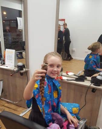 Izzy Morris, six, with the 30cm length of hair she is donating to the Little Princess Trust NNL-161213-145105001