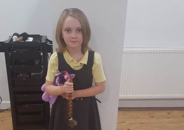 Izzy Morris, six, with her new hair do and the locks she will doante to the Little Princess Trust NNL-161213-144926001