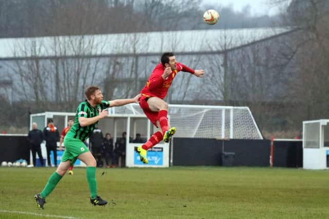 Banbury United's Ricky Johnson outjumps Cinderford Town's Dan Clare at the Banbury Plant Hire Community Stadium