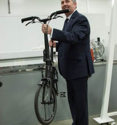 Dr Liam Fox with Prodrive's Hummingbird folding bike NNL-170124-115019001