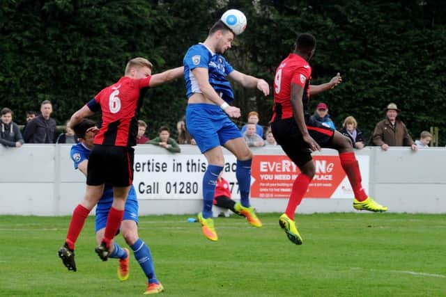 Salford City's Billy Priestley heads clear from Brackley Town's Gareth Dean and David Moyo