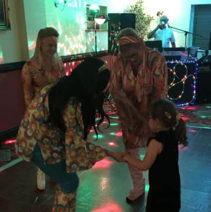 Alex Hutt, five, dances at her first disco with organiser Sue Bartholomew (centre), which was arranged to raise money for her physiotherapy as she has cerebral palsy