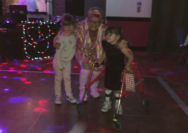 Twin sisters Izzy (left) and Alex with Sue Bartholomew, who organised the disco to raise money for Alex's cerebral palsy treatment NNL-170927-102918001