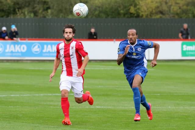 Brackley Town's  Ellis Myles and Billericay Town's  Ricky Modeste go for the ball at St James Park