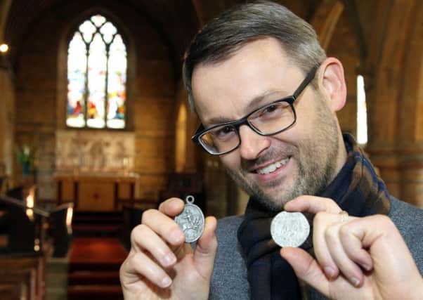 Jonn Mann holding coins and medals on display at the Battle of Edgehill exhibition at St Peter's Church in Radway. NNL-171022-110737009